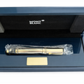 Gold pen with a clear plastic cover in an open blue 